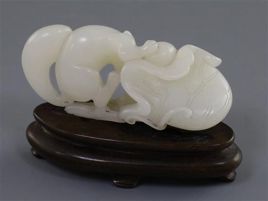 A Chinese white jade carving of a squirrel, grapes and lotus leaf, 18th/19th century, L. 6.4cm, wood stand